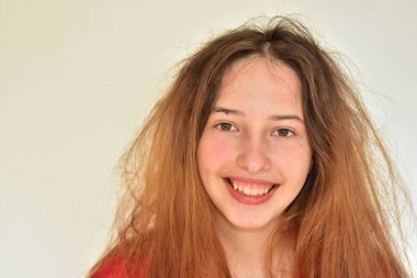 Bir kız beyaz arka planda bir işaret hareketi yapar.,