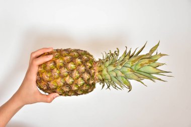Beyaz arkaplanda el ve ananas