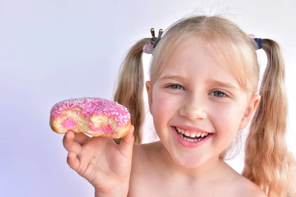 Klein Meisje Eet Een Roze Donut — Stockfoto
