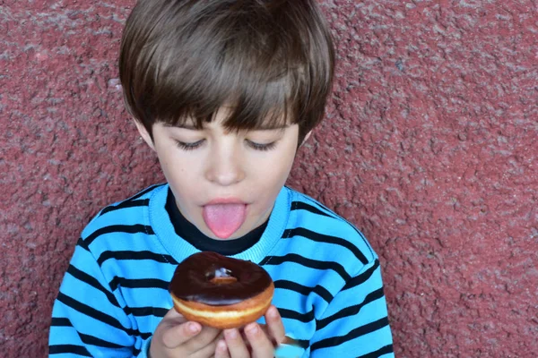 かわいい小さな男の子食べるドーナツ — ストック写真