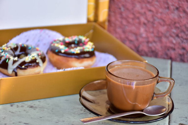 box with doughnuts and cup of coffee