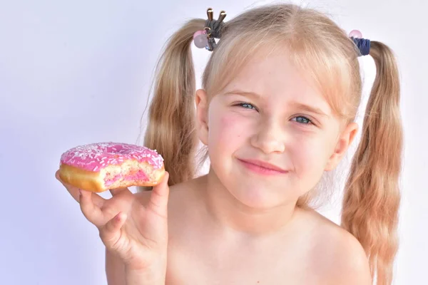 小女孩吃粉红色的甜甜圈 — 图库照片