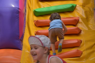 Çocuklar şişme kalede oynuyorlar.,
