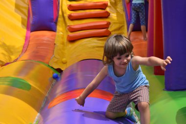 Çocuklar şişme kalede oynuyorlar.,