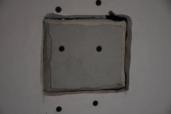 四角い穴とネジ付きの古い白い壁 — ストック写真