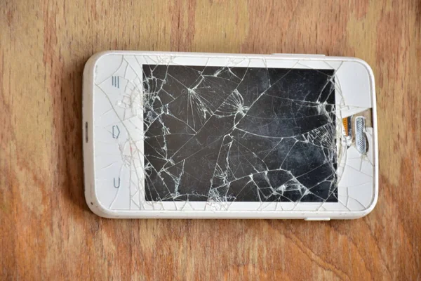 Ahşap arka planda kırılmış telefon -