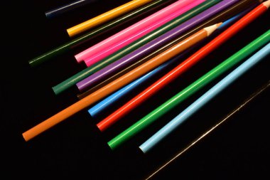 siyah bir arka plan üzerinde renkli kalemler 