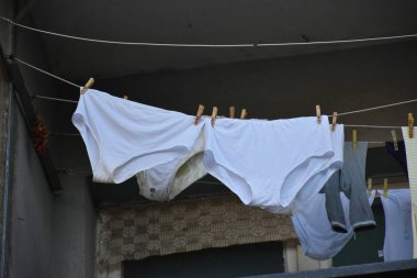 Yıkanmış giysiler ipe asılmış.
