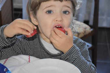 Çocuk çilek yiyor. 