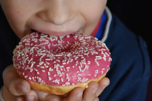 小さな男の子食べるドーナツ — ストック写真
