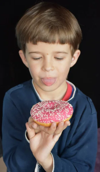 小さな男の子食べるドーナツ — ストック写真