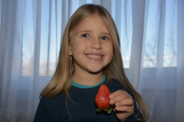 Çocuk çilek yiyor.