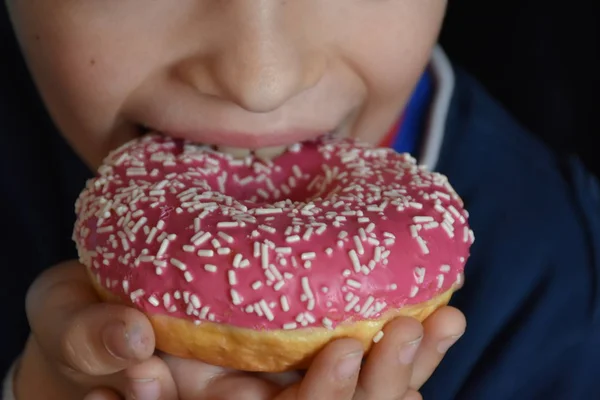 小さな男の子食べるドーナツ — ストック写真