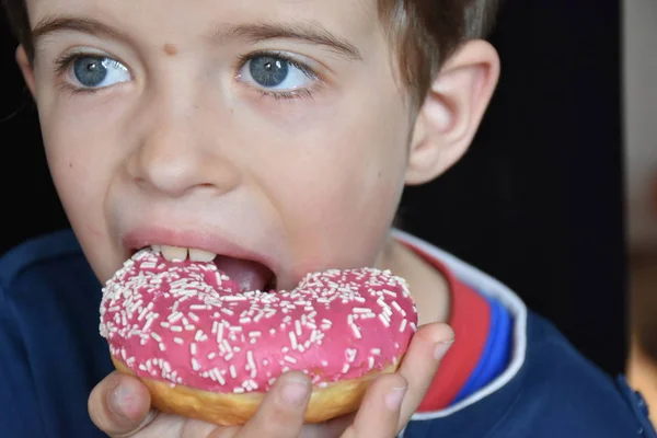 小さな男の子食べるドーナツ — ストック写真