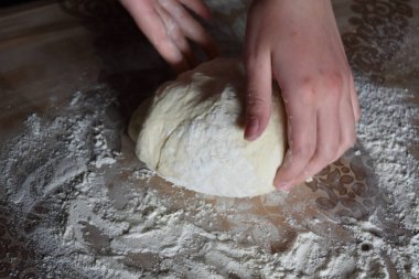 Kadın elleriyle hamur yoğurur.