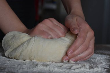 Kadın elleriyle hamur yoğurur.