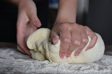 Kadın elleriyle hamur yoğurur.