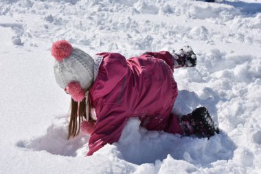 Çocuklar karda oynuyor.