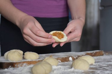 Kadın lahana dolu turtalar yapıyor. 