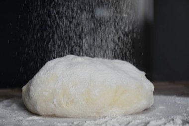 Kadın elleriyle hamur yoğurur.