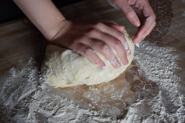 Kadın elleriyle hamur yoğurur.