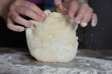 Kadın elleriyle hamur yoğurur.