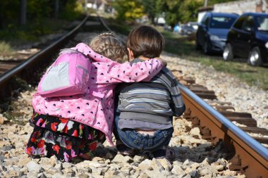 Kız ve oğlan demiryolunda.