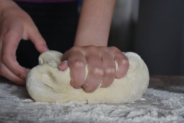 Kadın elleriyle hamur yoğurur.