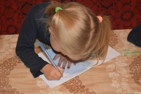 ノートにペンを書く女の子 — ストック写真