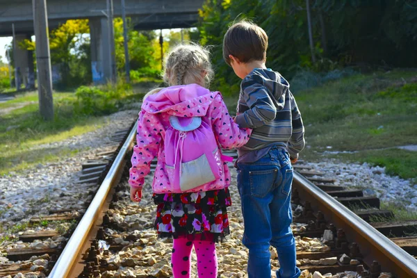 Kız ve oğlan demiryolunda.