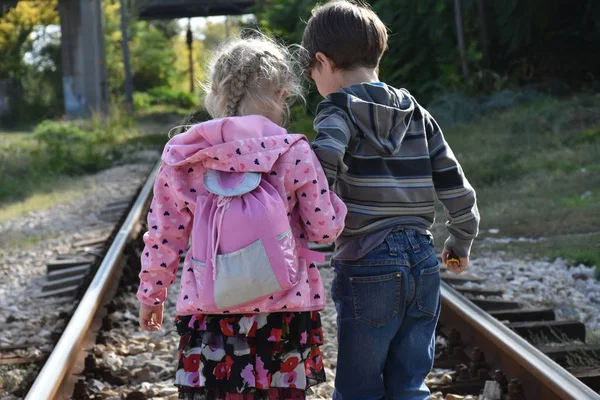 Kız ve oğlan demiryolunda.