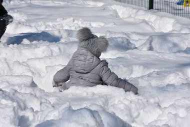 Çocuklar karda oynuyor.
