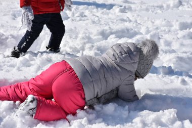 Çocuklar karda oynuyor.