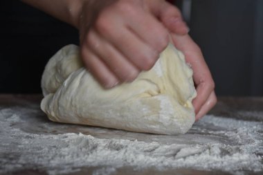 Kadın elleriyle hamur yoğurur.