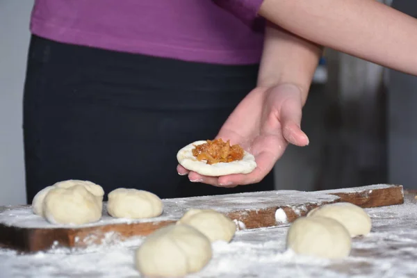 woman making pies filled with cabbage