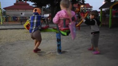 Üç mutlu çocuk oyun alanında eğleniyor.