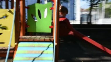 Yakışıklı küçük çocuk oyun alanında eğleniyor. 