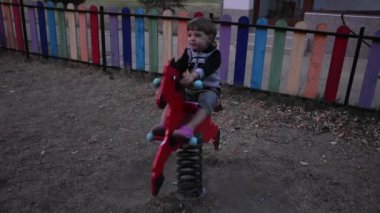 Küçük mutlu çocuk oyun alanında eğleniyor.