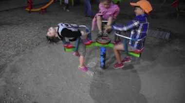 Üç mutlu çocuk oyun alanında eğleniyor.