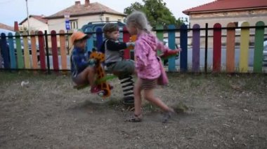 Üç mutlu çocuk oyun alanında eğleniyor.