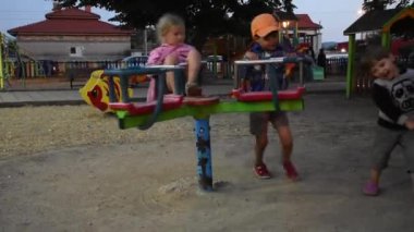 Üç mutlu çocuk oyun alanında eğleniyor.