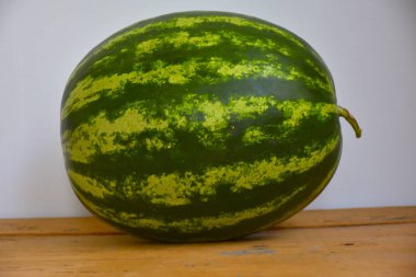 Ahşap masada olgun karpuz resmi.