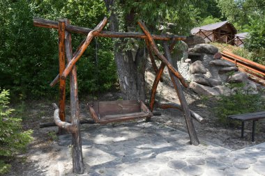 Arka bahçede el yapımı, pejmürde ahşap salıncak.