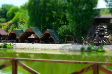 Kırsal gölet suyu, yaz günü, plajda dinlenen insanlar. 