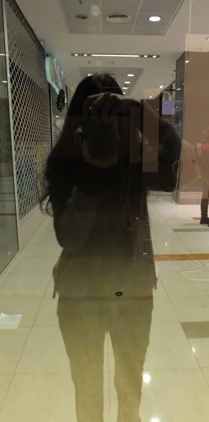 漂亮的女人用在玻璃中倒影的相机拍摄自拍照片 — 图库照片