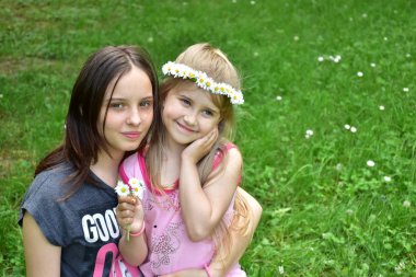 başlarında papatya bir çelenk ile iki kız portresi,