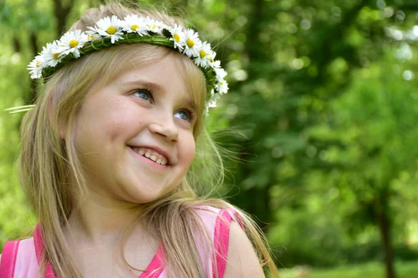 一个小女孩的肖像与雏菊花圈在她的头上 — 图库照片
