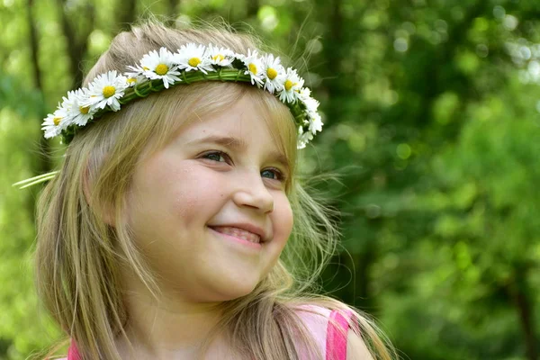 一个小女孩的肖像与雏菊花圈在她的头上 — 图库照片