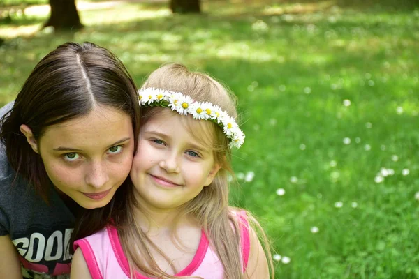 两个女孩的肖像与雏菊花圈在他们的头上 — 图库照片