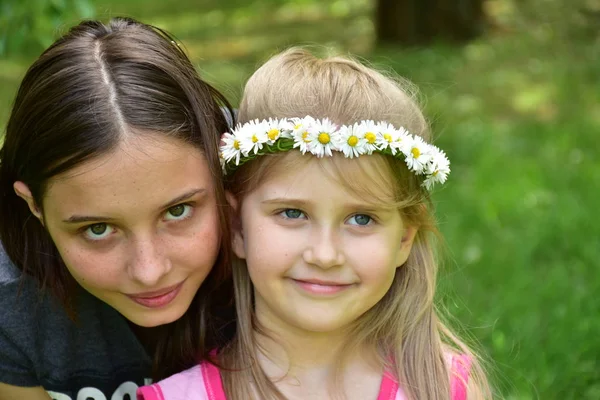 ヒナギクの花輪を頭に持つ2人の女の子の肖像画 — ストック写真